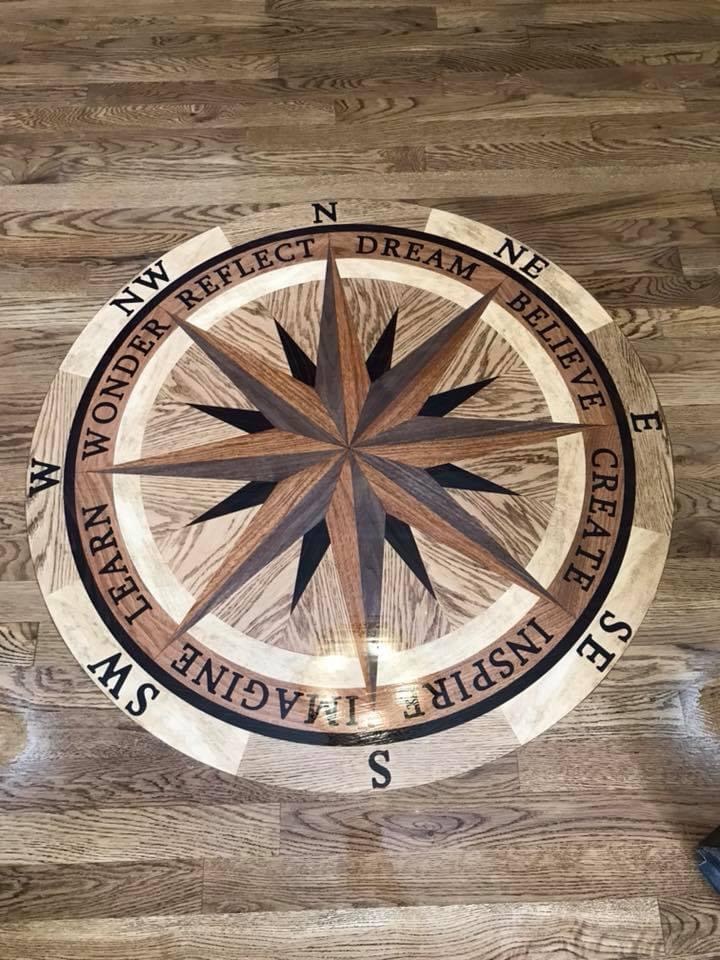 Decorative compass medallion installed within a hardwood floor